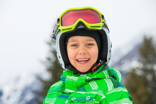 Skier, skiing, winter sport - portrait of Cute happy skier boy in a winter ski resort.