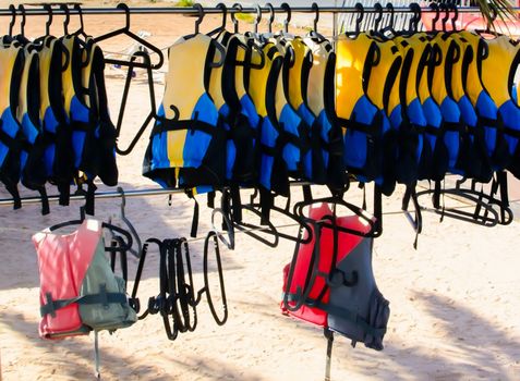 Life jackets hanging on a rack on a sandy beach. Mallorca, Balearic islands, Spain.