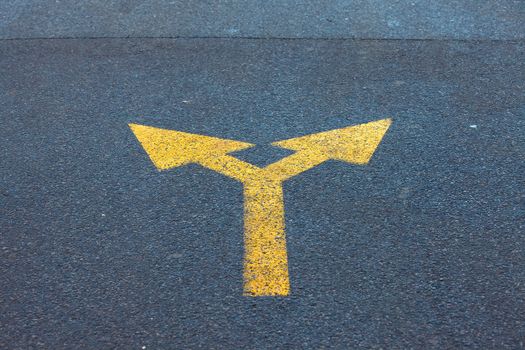 Arrow sign on the asphalt road