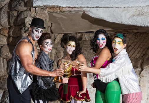 Martini drinking cirque clown ensemble toasting on stage