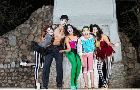 Group of surreal clowns on stage laughing