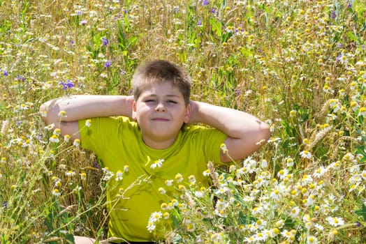 Boy in a field with a flowers