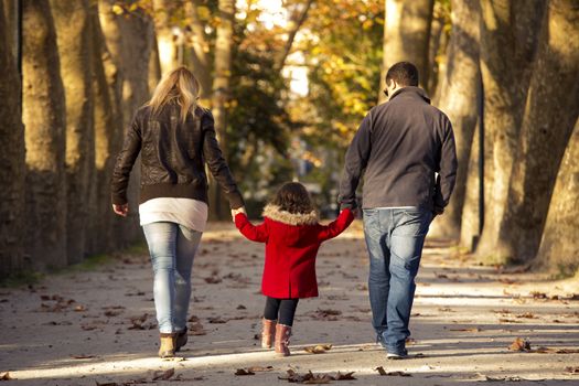 Outdoor portrait of a happy family walking together and enjoying the fall season