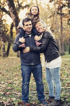 Outdoor portrait of a happy family enjoying the fall season