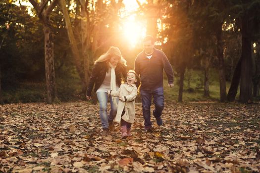 Outdoor portrait of a happy family enjoying the fall season