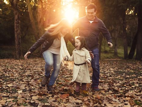 Outdoor portrait of a happy family enjoying the fall season