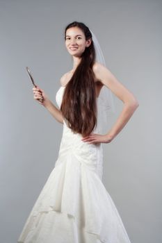 portrait od a bride with long dark hair in wedding dress - isolated on gray