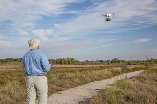 FORT COLLINS, CO, SEPTEMBER 28, 2014:  Photogrpaher, Marek Uliasz, is lflying the DJI Phantom 2 quadcopter drone with Panasonic Lumix GM1 camera on board over a marsh natural area.