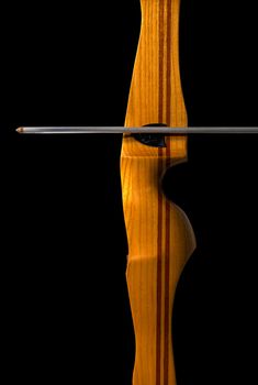 Detail of a sports wooden bow and arrow on black background