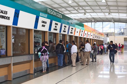 QUITO, ECUADOR - AUGUST 8, 2014: Unidentified people standing in line to buy bus tickets for long-distance buses at the Terminal Terrestre Quitumbe on August 8, 2014 in Quito, Ecuador. In Ecuador, many different bus companies provide transport services, each of them having a separate ticket office.
