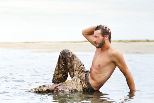 Portrait of Muscle man during fitness training on the water ocean