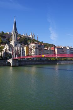 View of Lyon city with red footbridge on Saone river and church 