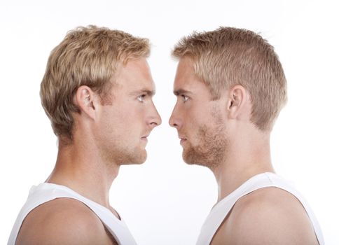 portrait of young twin brothers standing face to face- isolated on white