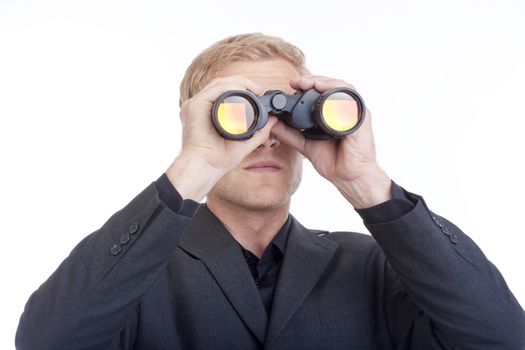 businessman in suit looking through binoculars - isolated on white