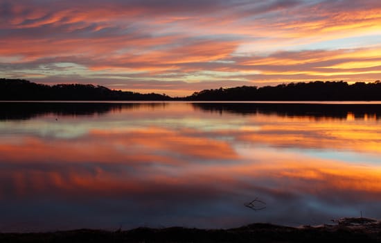 Spectacular cloud reflections on Narrabeen Lakes at sunrise.