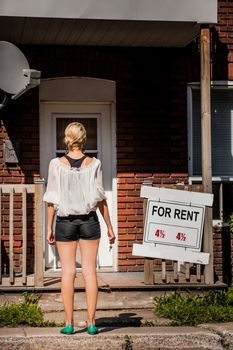 Young Woman standing with keys in front of her new apartment