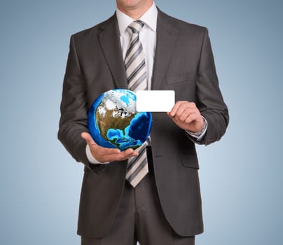 Businessman in suit hold empty card and Earth. Elements of this image are furnished by NASA