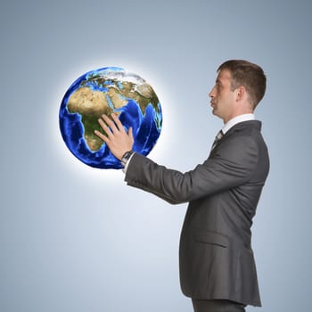 Businessman in suit hold Earth. Elements of this image are furnished by NASA