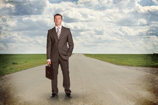 Businessman in suit with briefcase standing on the road. Business concept