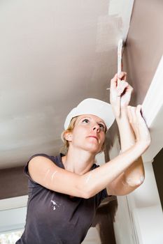 Closeup of Woman Holding Paint Brush and Painting the Ceiling