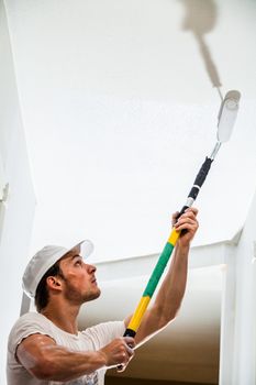 Closeup of Man Holding Roller Pin and Painting the Ceiling