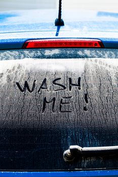 Wash Me Words on a Dirty Rear Car Window