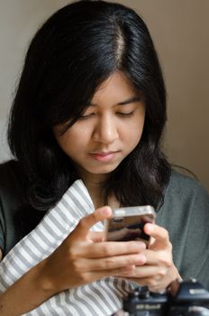 Pretty young asian woman using mobile phone 