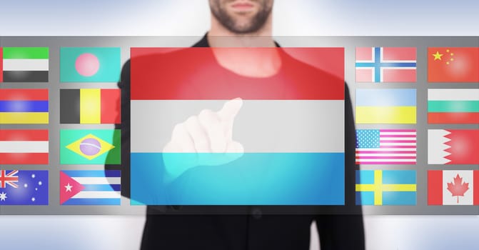 Hand pushing on a touch screen interface, choosing language or country, Luxembourg