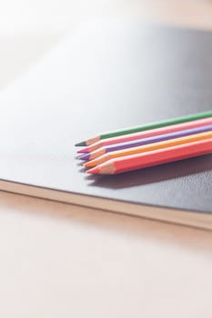 Color pencils on black notebook, stock photo