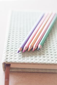 Closeup color pencils on green notebook, stock photo
