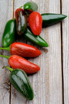 Stack of Red and Green Habanero and Jalapeño Chili Peppers isolated on Rustic Wooden background