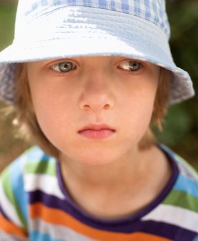 Portrait of a Boy with Blond Hair and Hat Outdoors