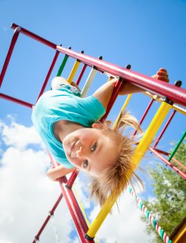 Little girl having fun playing on monkey bars