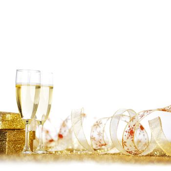 Glasses of champagne and presents on golden glitter background