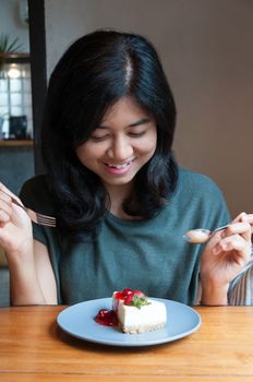 Young beautiful asian woman prepare to eating a cake in cafe