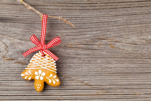 Gingerbread cookie hanging on wooden background. Christmas decoration.