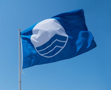 Blue flag on beach. Cala Estancia, Mallorca, Balearic islands, Spain in July.
