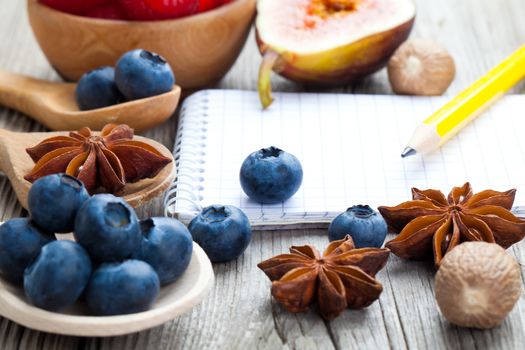 top view of recipe book with ingredients on wooden table