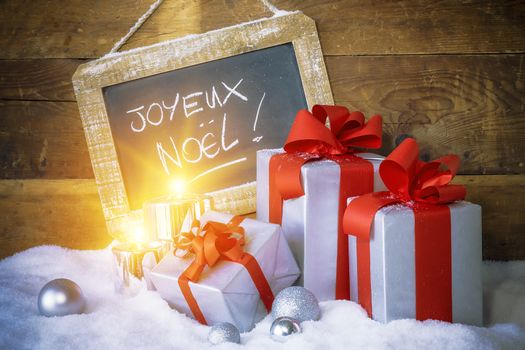 Closeup of Christmas gifts with candles and slate.