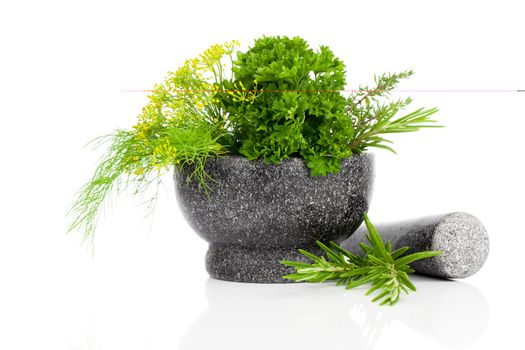 Stone mortar with green herbs, on white background