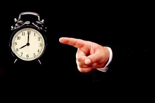 Businessman hand pointing alarm clock. Time for work concept