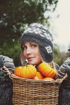 Girl holding basket of pumpkins for Thanksgiving