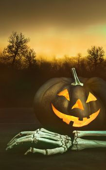 Pumpkin with skeleton hand with dark background