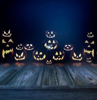 Halloween pumpkins in a dark eerie background and wood floor