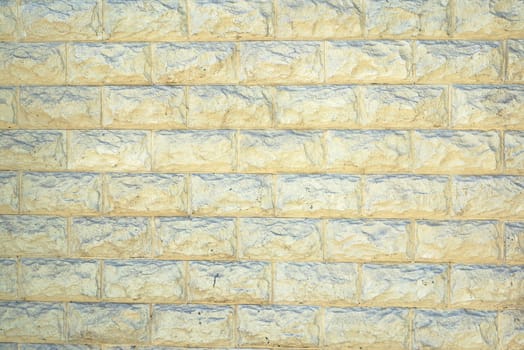 The wall of the large light yellow rectangular stones as a background