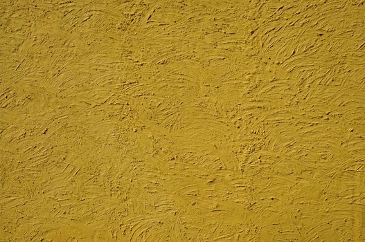 The texture of mustard color walls painted large erratic strokes of pain                               