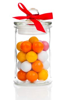 Colorful background of assorted Gumballs in  glass jar,  isolated over white background