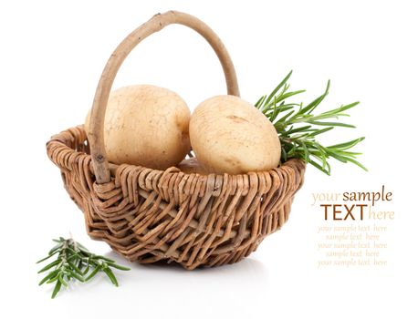 Golden Potatoes in wicker basket, with rosemary over white background