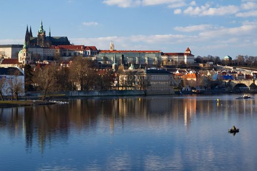 Photo shows various historical houses, Vltava river, bridges and other architectural details.