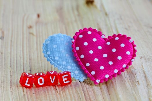 Photo shows details of love sign with heart on the wooden background.